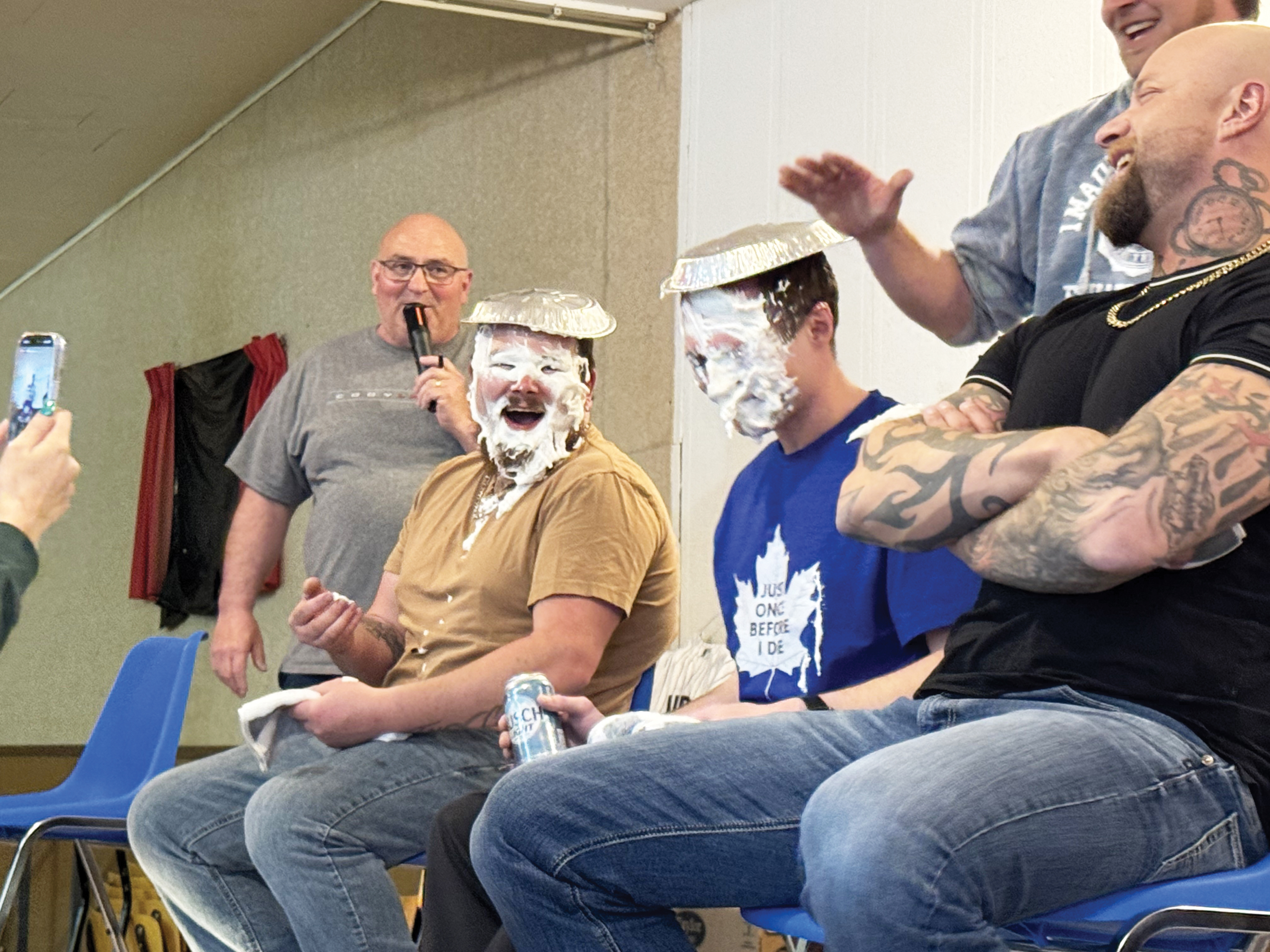 From left to right, MC Mike Wilson and Tim Englot enjoyed watching as Luke McCrimmon got a face full of pie from Willy Brimner. <br />
